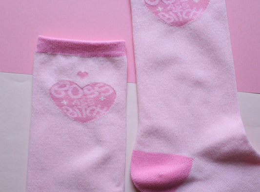 Pink socks with heart designs on a pink background